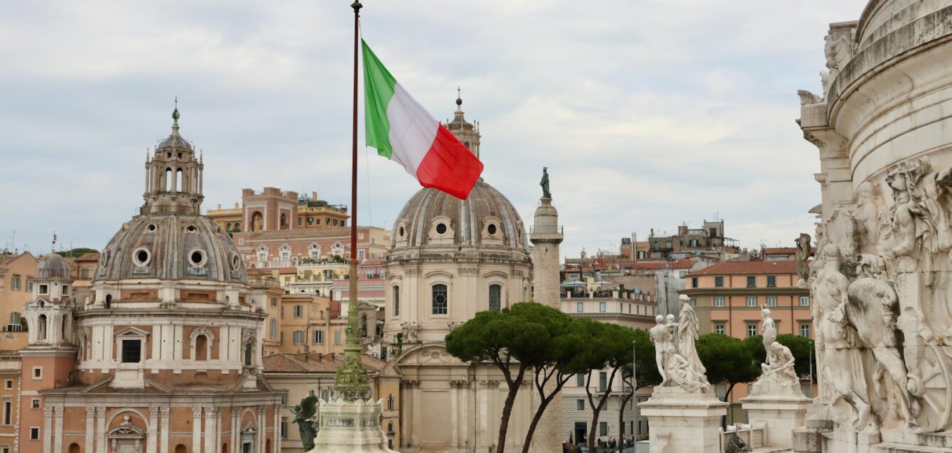 a flag flying in the air over a city